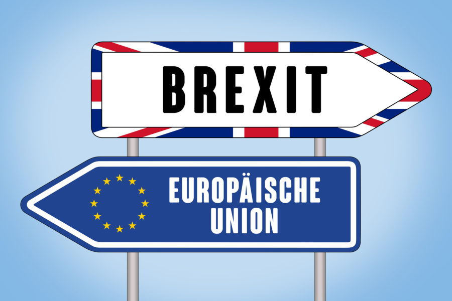 two road signs pointing in opposite directions. One says Brexit, the other Europäische Union